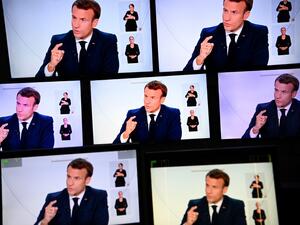This picture shows screens displaying French President Emmanuel Macron as he addresses the nation during a televised interview from the Elysee Palace concerning the situation of the novel coronavirus Covid-19 in France, in Paris on October 14, 2020. President Emmanuel Macron on Wednesday ordered a nighttime curfew for Paris and eight other French cities to contain the rising spread of Covid-19 in the country. In a televised interview, Macron said residents of those cities would not be allowed to be outdoors