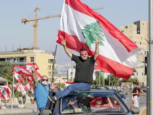 Lebanese demonstrators wave the national flag as they drive to a demonstration, marking the first anniversary of a non-sectarian protest movement, in the capital Beirut's downtown area on October 17, 2020. (AFP/File)