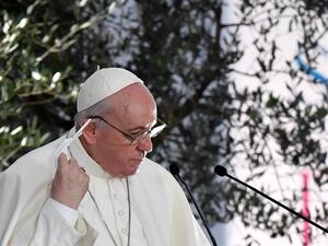 Pope Francis takes off his face mask prior to delivering a speech during a ceremony for peace with representatives from various religions in Campidoglio Square in Rome on October 20, 2020. Andreas SOLARO / AFP