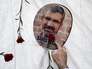  In this file photo taken on November 28, 2016 a man touches a portrait of late Kurdish lawyer Tahir Elci, displayed next to red flowers (carnations) in Diyarbakir, during a ceremony in tribute to the lawyer, near the historical mosque where he was shot dead last year. A long-awaited trial opened on October 21, 2020, of three police officers for the 2015 killing of a prominent rights lawyer in Diyarbakir, Turkey's biggest Kurdish-majority city. Tahir Elci, who campaigned for Kurdish rights, was shot in the 