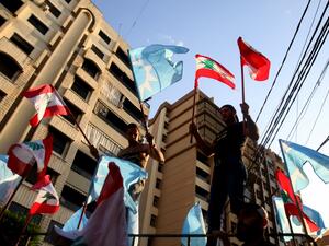 Supporters of Saad Hariri's Future Movement Party wave the party flag and the national flag during a parade to celebrate him being tasked with forming a new government in Lebanon's southern city of Sidon (Saida) on October 22, 2020. Three-time Lebanese prime minister Saad Hariri was renamed to the post to create a reform-orientated cabinet that can lift the country out of its worst economic crisis in decades. Mahmoud ZAYYAT / AFP