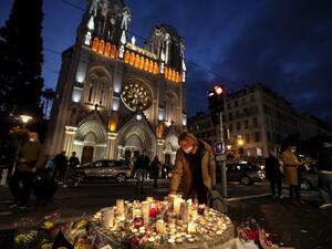 People lights candle outside the Notre-Dame de l'Assomption Basilica in Nice on October 30, 2020, a day after a knife attacker killed three people, cutting the throat of two, inside the church of the French Riviera city, and police arrest a young Tunisian migrant from Sfax who arrived in Europe only last month, according to French prosecutors. (AFP/File)