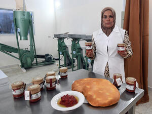 The manager of a cooperative for making harissa paste poses boxes of the produce in  Menzel Mehiri in Kairouan governorate some 200 kilometres south of Tunis. (AFP)