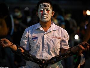 A pro-democracy protester wears chains and make-up during a demonstration at a road intersection in Bangkok today, after Thailand issued an emergency decree following an anti-government rally the previous day. (AFP/File)
