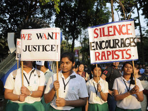School girls in uniform holding signs asking for justice during a candle light vigil to protest gang rape of an elderly nun on March 16, 2015 at Allen Park in Kolkata, India. (Shutterstock/ File Photo)