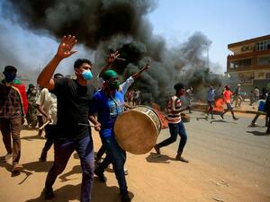 Sudanese demonstrators carrying a drum gesture as smoke billows from burning tires during a protest east of the capital Khartoum, Sudan, June 30, 2020. Ashraf Shazly/AFP via Getty Images, FILE