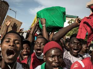 Demonstrators carry a coffin as they take part in a march in the streets of Dakar, on October 30, 2020, called by the Guinean diaspora to protest against the results of the presidential elections in Guinea. Protests against Guinea's President Alpha Conde will resume next week, the political opposition said on October 30, 2020, after 10 losing candidates in the country's election rejected the official outcome. JOHN WESSELS / AFP