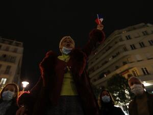 A woman sings the "Marseillaise", the French national anthem, outside Notre-Dame de l'Assomption Basilica in Nice on October 31, 2020, to pay tribute to the victims two days after a knife attacker killed three people, cutting the throat of two, inside the church of the French Riviera city. Valery HACHE / AFP