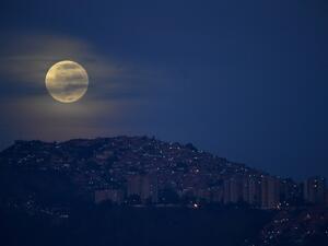 The "blue moon", the second full moon of a calendar month, is seen over the Valle shantytown in Caracas, on October 31, 2020. Federico PARRA / AFP