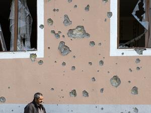 A man walks in front of a residential building damaged in shelling during the ongoing military conflict between Armenia and Azerbaijan over the breakaway region of Nagorno-Karabakh, in the town of Terter on November 1, 2020. TOFIK BABAYEV / AFP