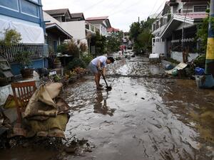 A resident shovels mud from a neighbourhood street following flooding in Batangas City on November 2, 2020, after super Typhoon Goni made landfall in the Philippines on November 1. TED ALJIBE / AFP