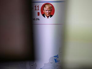 A news channel features portrait of US presidential candidates Donald Trump is pictured at a foreign exchange trading company in Tokyo on November 4, 2020, as Asian markets react to early predictions following the US presidential election. Philip FONG / AFP