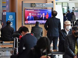 People watch a television news programme reporting on the US presidential election showing images of US President Donald Trump (L) and Democratic presidential candidate Joe Biden (R), at a railway station in Seoul on November 4, 2020. Jung Yeon-je / AFP