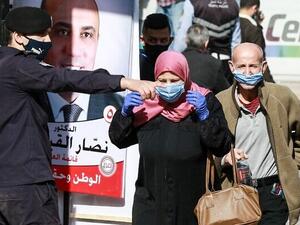 A member of the Jordanian security forces directs voters outside a polling station in Jordan’s capital Amman on November 10, 2020, during the 2020 general election. (Khalil MAZRAAWI/AFP)