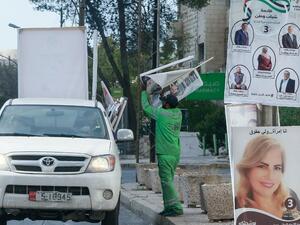 Jordanian minicipal workers remove campaign posters a day after parliamentary elections in the capital Amman, on November 11, 2020. Jordanians voted on November 10 in a parliamentary election overshadowed by the coronavirus pandemic, which has dealt a heavy blow to the Arab country's already debt-ridden economy. Khalil MAZRAAWI / AFP