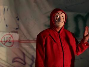 A protester stands next to part of the Democracy Monument draped with a large white sheet with pro-democracy messages from activists during an anti-government rally in Bangkok on November 14, 2020. Jack TAYLOR / AFP