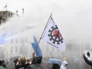 Police use a water cannon to disperse protesters demonstrating against measures imposed by the German government to limit the spread of the novel coronavirus, on November 18, 2020 at the Brandenburg Gate in Berlin. After repeated warnings for the crowd to put on face coverings went unheeded, police said they would take action to clear the protest and "detain violators". Around 5,000 activists massed at the Brandenburg Gate, after the German government banned rallies outside parliament because of fears of vi