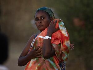 An Ethiopian refugee who fled fighting in Tigray province carries her baby as she walks at the Um Rakuba camp in Sudan's eastern Gedaref province, on November 21, 2020. AFP