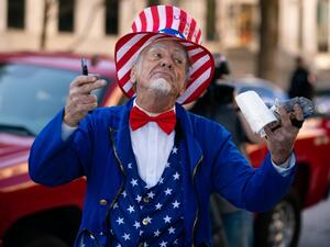 A man riding a Segway dressed as Uncle Sam taunts Biden supporters during a "Stop the Steal" rally against the results of the U.S. Presidential election outside the Georgia State Capitol on November 18, 2020 in Atlanta, Georgia. Elijah Nouvelage/Getty Images/AFP Elijah Nouvelage / GETTY IMAGES NORTH AMERICA / Getty Images via AFP
