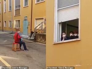 Stefano Bozzini (left) plays his accordion to his wife Carla Sacchi (right) from the street below. (Facebook)