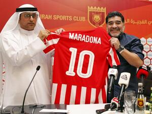 Photo taken on May 14, 2017  Diego Armando Maradona (R) holds a jersey of the football club Fujairah FC, bearing his name, during a press conference where he was announced as the upcoming manager for the team (Photo: AFP)
