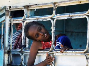 لاجئ إثيوبي ينظر من نافذة حافلة في مخيم الحمديات المؤقت للاجئين