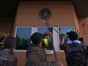 Iraqi supporters and members of the Popular Mobilization Forces paramilitary pull off a plaque from the entrance of the US embassy in Baghdad, Iraq, December 31, 2019. (Ahmad al-Rubaye/AFP)