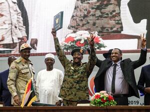 In this file photo taken on August 17, 2019, Sudan's protest leader Ahmad Rabie (2nd-R), flashes the victory gesture alongside General Abdel Fattah al-Burhan (C), the chief of Sudan's ruling Transitional Military Council (TMC), during a ceremony where they signed a "constitutional declaration" that paves the way for a transition to civilian rule, in the capital Khartoum, accompanied by General Mohamed Hamdan Daglo "Hemeti" (2nd-L), TMC deputy chief and commander of the Rapid Support Forces (RSF) paramilitar