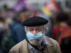 A man smokes a pipe while wearing a face mask during a demonstration in Nantes, western France, on June 30, 2020, as part of a nationwide day of protests to demand better working conditions for health workers. Loic VENANCE / AFP