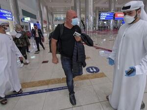 Illustrative: An Israeli man walks past Emirati staff after passport control upon arrival from Tel Aviv to the Dubai airport in the United Arab Emirates, on November 26, 2020. (Karim SAHIB / AFP)
