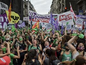 Demonstrators celebrate with green headscarves - the symbol of abortion rights activists - outside the Argentine Congress in Buenos Aires on December 11, 2020, after legislators passed a bill to legalize abortion. RONALDO SCHEMIDT / AFP