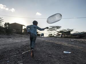 A boy runs with a balloon in the village of Bisober, in Ethiopia's Tigray region on December 9, 2020. The November 14 killings represent just one incident of civilian suffering in Bisober, a farming village home to roughly 2,000 people in southern Tigray.  EDUARDO SOTERAS / AFP