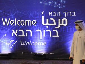 An Emirati man walks past a sign welcoming guests to a ceremony for the signing of a memorandum of understanding between the UAE and the Israeli football assosiations in Dubai, on December 14, 2020. Karim SAHIB / AFP