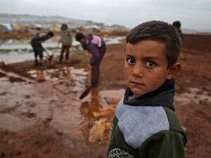 A Syrian child poses for a picture at a camp for displaced Syrians near the town of Kafr Lusin by the border with Turkey, in Syria's rebel-held northwestern province of Idlib on December 15, 2020. Aaref WATAD / AFP