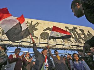 Iraqi protesters take part in a demonstration at Tahrir Square in Baghdad on December 21, 2020. Hundreds of angry Iraqis protested in several cities against a currency devaluation that has slashed their purchasing power amid a pandemic-fuelled economic crisis. The Central Bank of Iraq at the weekend devalued the dinar by nearly a quarter against the US dollar, officially re-pegging the dinar at 1,450 to the greenback.  Sabah ARAR / AFP