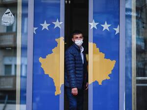 A man exits a government building decorated with Kosovo's flag in Pristina on December 22, 2020. Kosovo was preparing to call a snap poll, after its top court ruled last year's election of Prime Minister Avdullah Hoti was unconstitutional, delivering fresh upheaval to the democracy's crisis-hit politics.  Armend NIMANI / AFP