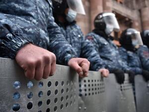 Law enforcement officers watch opposition supporters during a rally to demand the resignation of Prime Minister Nikol Pashinyan over a controversial peace deal with Azerbaijan that ended six weeks of war over the disputed region of Nagorno-Karabakh, in Yerevan on December 22, 2020. Under the deal, Armenia agreed to cede three districts to Baku in addition four others Azerbaijani forces had won back during the fighting that had been controlled by Armenian separatists since the 1990s. Karen MINASYAN / AFP
