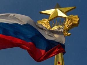 A photograph taken on December 27, 2020 shows the Russian national flag flapping on the wind in front of the Soviet Union symbols placed on the top of a building, in Moscow. Kirill KUDRYAVTSEV / AFP