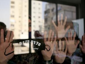 Lebanese woman display a protective mask hiding a hot number distributed by the NGO ABAAD in Beirut on 08 December 2020. (PATRICK BAZ / ABAAD)