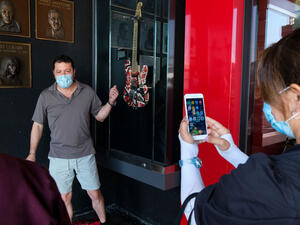 A man poses next to an Eddie Van Halen’s guitar displayed at the California Rockwalk of Fame in Los Angeles, Tuesday, Oct. 6, 2020. (shutterstock)