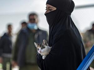 A Syrian woman, suspected of being related to Islamic State (IS) group fighters, carries a cat at the Kurdish-run al-Hol camp, before being released to return to their homes, in the al-Hasakeh governorate in northeastern Syria, on December 21, 2020. Delil SOULEIMAN / AFP