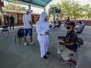 A health worker interviews a Venezuelan man in Cucuta, on the Colombian border with Venezuela, as he waits to get a Covid-19 test at a testing center, on December 28, 2020. Colombia has been one of the worst hit countries in Latin America by the pandemic with more than 1.5 million cases and over 40,000 deaths. Schneyder MENDOZA / AFP
