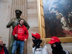 Supporters of US President Donald Trump pose with statues inside the Rotunda after breaching the US Capitol in Washington, DC, January 6, 2021. The demonstrators breeched security and entered the Capitol as Congress debated the 2020 presidential election Electoral Vote Certification. SAUL LOEB / AFP