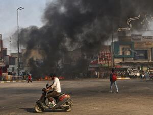 Iraqi protesters are pictured next to burning tyres during clashes with police during anti-government demonstrations in the city of Nasiriyah in the Dhi Qar province in southern Iraq on January 10, 2021. AFP