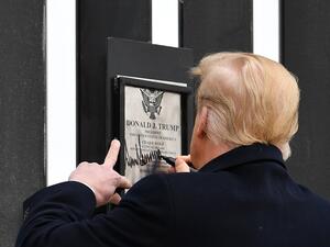 US President Donald Trump signs plaque on the border wall in Alamo, Texas on January 12, 2021. MANDEL NGAN / AFP
