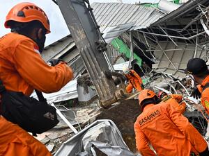 Rescuers search for survivors at the site of a collapsed building in Mamuju on January 16, 2021, a day after a 6.2-magnitude earthquake rocked Indonesia's Sulawesi island. Hariandi Hafid / AFP