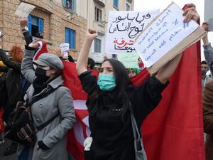 Tunisian protesters lift placards and national flags during an anti-government demonstration in the capital Tunis, on January 23, 2021. Tunisia braced for further protests after hundreds were arrested in four nights of street clashes between riot police and disaffected youths in cities across the North African country. FETHI BELAID / AFP