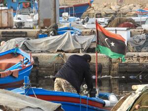 A man rummages through a boat moored at the port of Libya's capital Tripoli on January 24, 2021. Mahmud TURKIA / AFP
