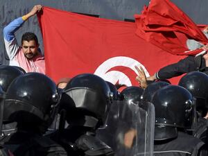 Tunisian police block protesters from accessing the parliament building on January 26, 2021 in Tunis. Tunisian anti-government protesters marched toward the parliament building, which was guarded by riot police as lawmakers inside held a heated debate on a cabinet reshuffle. FETHI BELAID / AFP