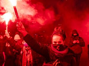 Demonstrators light flares during a pro-choice demonstration in front of the constitutional court in Warsaw, Poland, on January 28, 2021, as part of a nationwide wave of protests since October 22, 2020 against Poland's near-total ban on abortion. Hundreds of Poles rallied in Warsaw against a controversial court verdict imposing a near-total ban on abortion. Protesters also took to the streets elsewhere in the EU member in what was the second night of outrage after the Constitutional Court ruling came into e